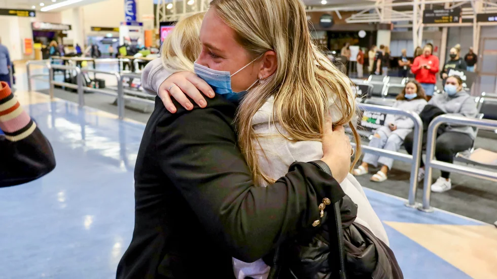 Familjemedlemmar kramar om varandra efter det att ett flyg från Los Angeles anlände till Auckland i måndags.