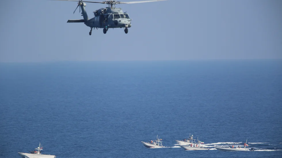 En amerikansk militärhelikopter övervakar fartyg som tillhör Irans revolutionära garde i en tidigare närkontakt. Arkivbild.