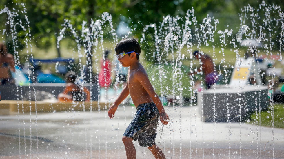 En pojke svalkar sig i en park i Calgary, i kanadensiska Alberta, en het junidag.
