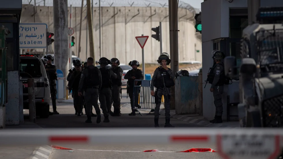 Israeliska soldater samlas vid den vägspärr mellan Jerusalem och Ramallah i Västbanken, där en kvinna sköts till döds efter att hon knivbeväpnad närmat sig gränsvakterna.