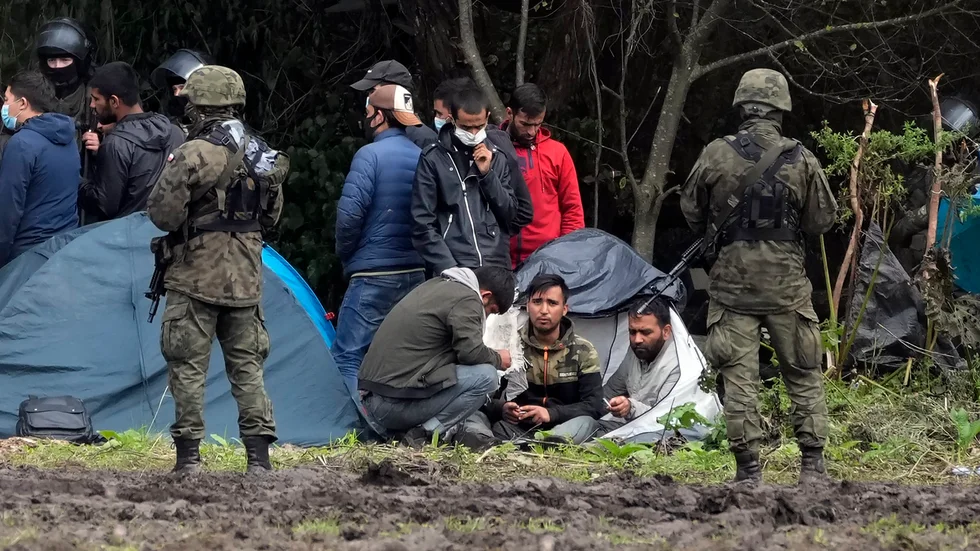 Migranter vid gränsen mellan Belarus och Polen. Nu har parlamentet i Polen godkänt att en gränsmur byggs mellan länderna. Arkivbild från 1 september i år.