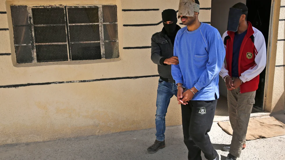 Alexanda Kotey eskorteras av kurdisk säkerhetstjänst efter gripandet i Syrien 2018.