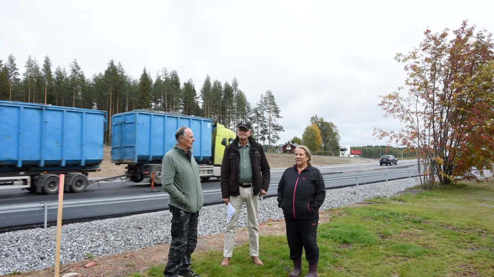 Den tunga trafiken på väg 97 är påtagligt närvarande, då vägkanten numera ligger 15 meter från bostadshuset. Björn Holmberg, Jan-Ove Wikström och Ysanne Samuelsson står i kanten på Wikströms tomt.