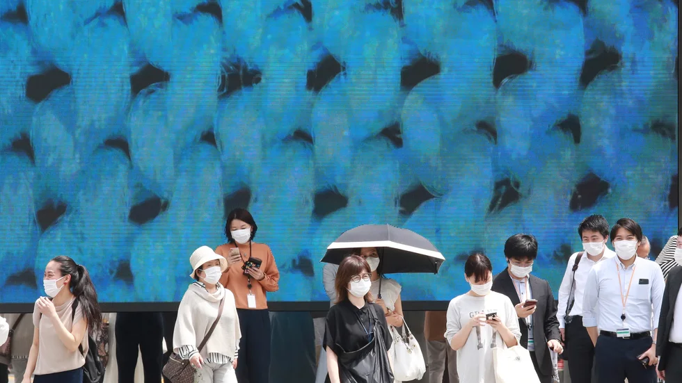 Människor med ansiktsmasker i OS-staden Tokyo på måndagen. Arkivbild.
