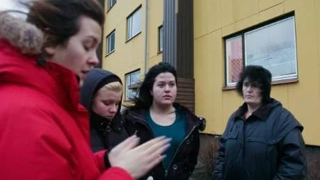 Alisa Kazlagic, Marie-Therese Myllynen, Sunita Kazlagic och Admira väcktes alla mitt i natten av polisen efter bomblarmet på Stockholmsvägen.   - Vi fick snabbt ta på oss något varm och sedan fick vi gå till en uppsamlingsplats, säger Alisa. I bakgrunden fönstret där den misstänkta bomben kastades in.                                                                                                                                              Foto: Titti Olovsson