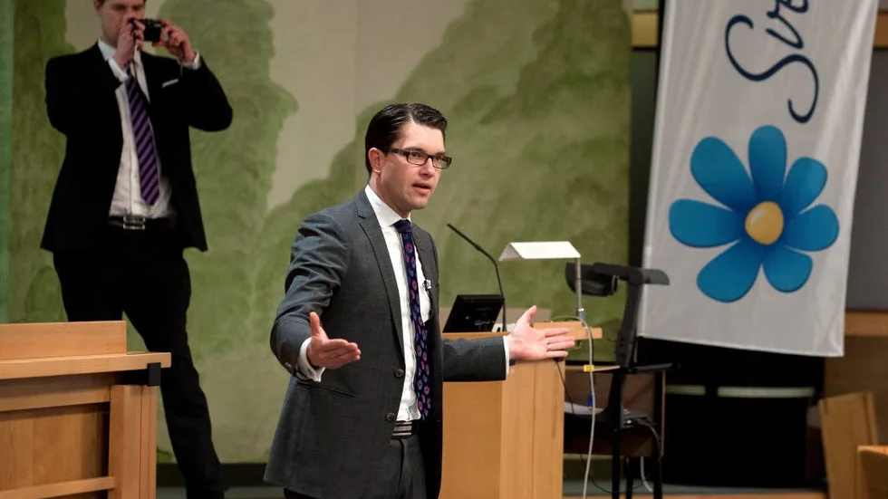 Jimmie Åkesson talar till partifolket, bakifrån fotograferad av Oscar Sjösten, som bland annat är  partiets politiskt sakkunnige i finans- och skattefrågor.