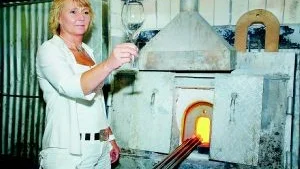 Kerstin Nordetun, marknads- och försäljningsansvarig på Reijmyre Glasbruk, framför en av glasbrukets ugnar. Det har gått bra för glasbruket den senaste tiden. Både försäljningen och antalet besökare till glasbruket har ökat.Foto: Johan Gustafsson