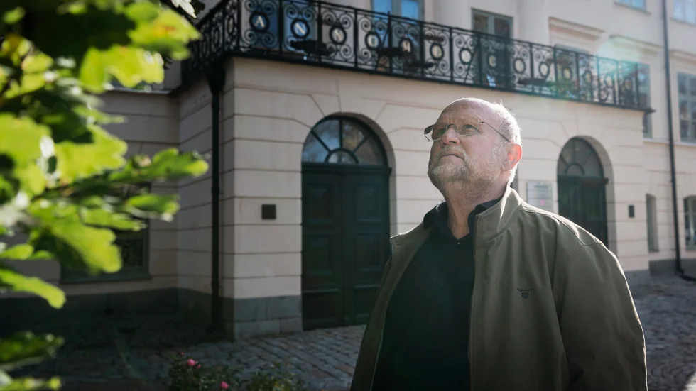 Ola Larsmo utanför Dekanhuset mellan Domkyrkan och Heliga Trefaldighets kyrka. Här läste han teologi en gång i tiden. I samma byggnad låg Statens institut för rasbiologi på 1920- och 30-talet.