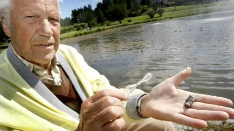 Enar Björkqvist visar upp linan med sänke som satt runt den lilla knipungens hals.