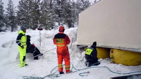 Chauffören Dan Sörensen (till vänster) klarade sig oskadd. Bärgningsteamet fick dock kämpa i många timmar för att få lastbilen och släpet på rätt köl igen.