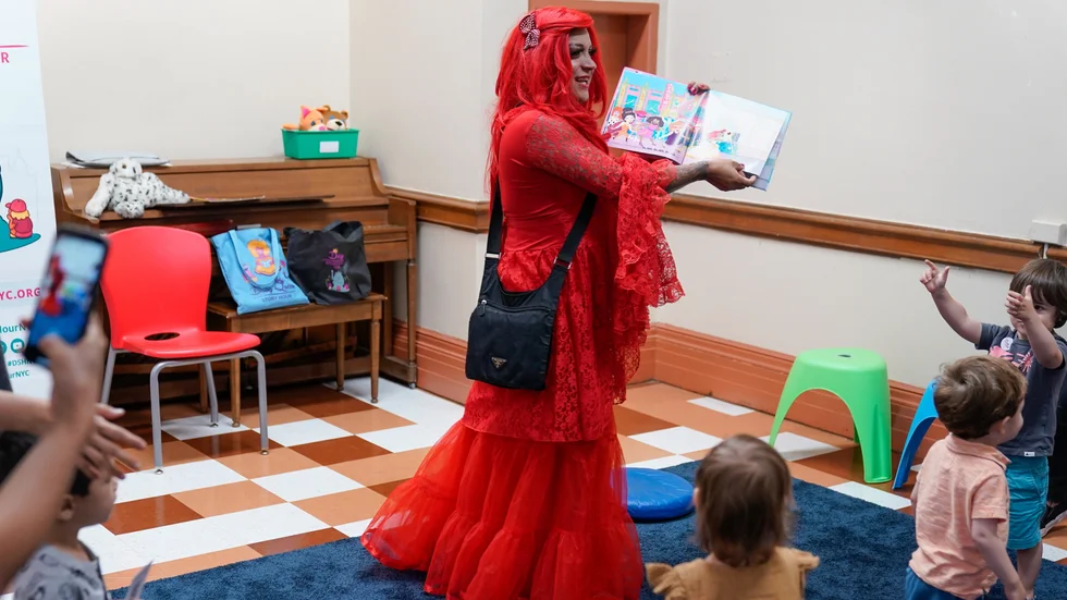Dragartisten Flame från Drag Story Hour i USA läser böcker för barn på ett bibliotek i New York.