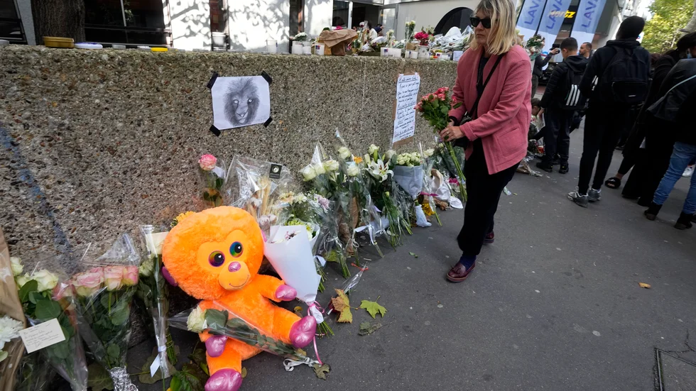 En kvinna lägger blommor utanför det lägenhetshus i Paris där 12-åriga Lola hittades mördad. Arkivbild från i onsdags förra veckan.