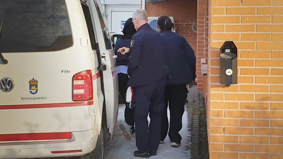 Den huvudåtalade kvinnan förs in till förhandlingen i Gällivare tingsrätt av kriminalvårdens personal.