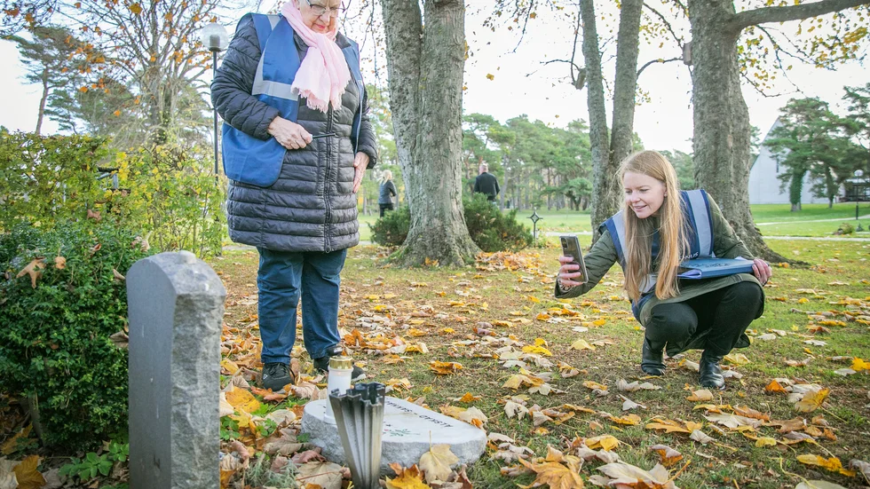 Birgitta Nylund, till vänster, från PRO arbetar frivilligt tillsammans med begravningsentreprenören Caroline Bengtsson, för att tända ljus vid gravar inför allhelgona.