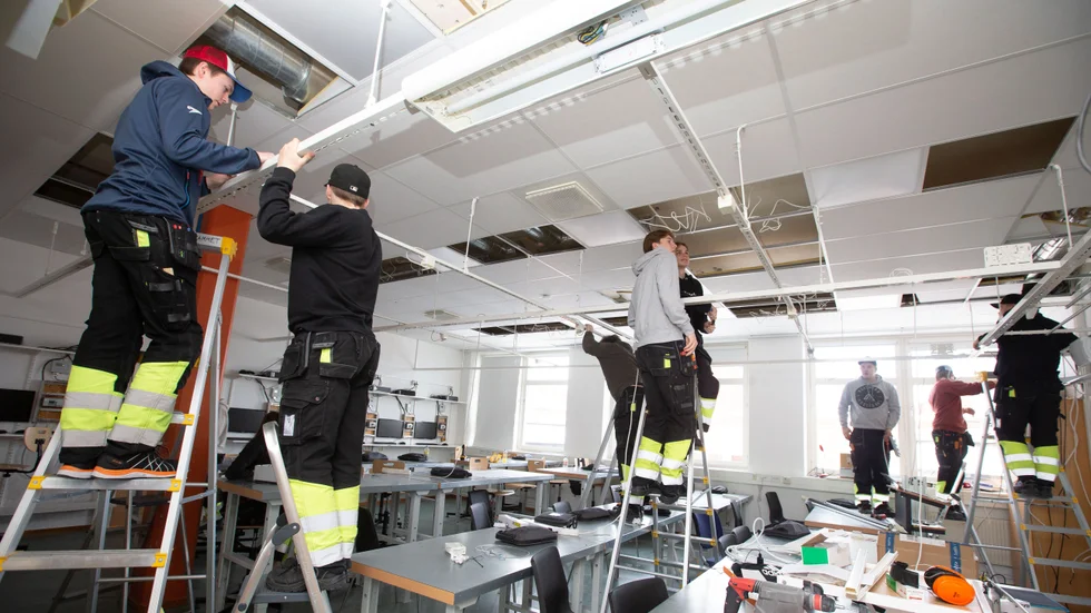 Det är full aktivitet i klassrummet när eleverna i årskurs två byter ut gamla armaturer och skenor mot ny ledbelysning.
