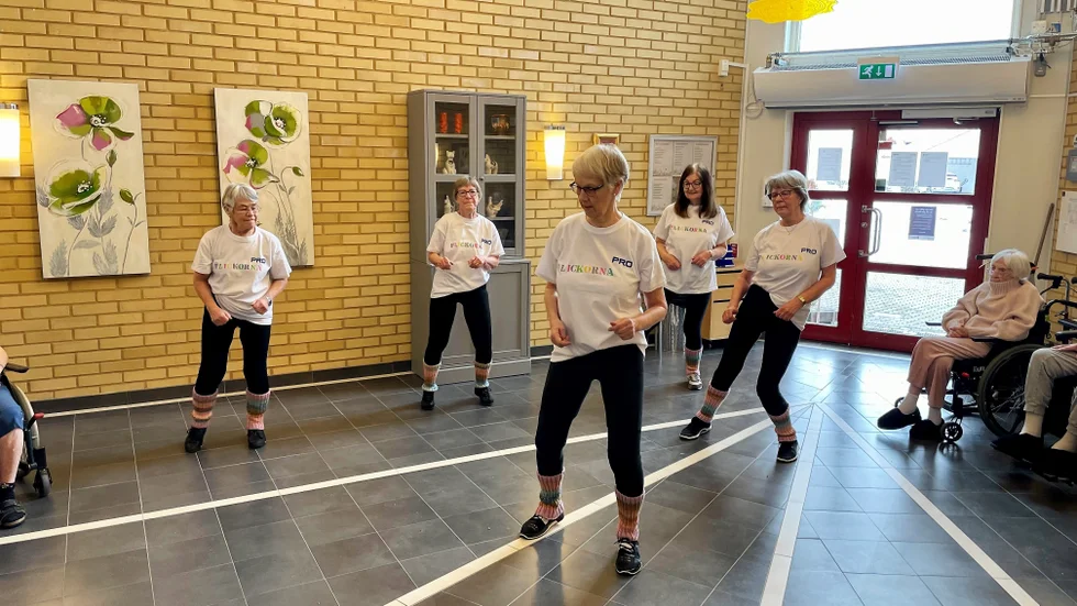 PRO-flickorna dansar loss i hallen på Kungsgården, där en stor andel av de boende bildar publik.