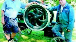 Krut i gamla maskiner. Bosse Ellergren och Hasse Åkesson, till höger, har fått Hembygdsföreningens tändkulemotor Vimmerby Beijer 1924 på plats.                                                                        FOTO: MARGARETA LJUNGBLAD