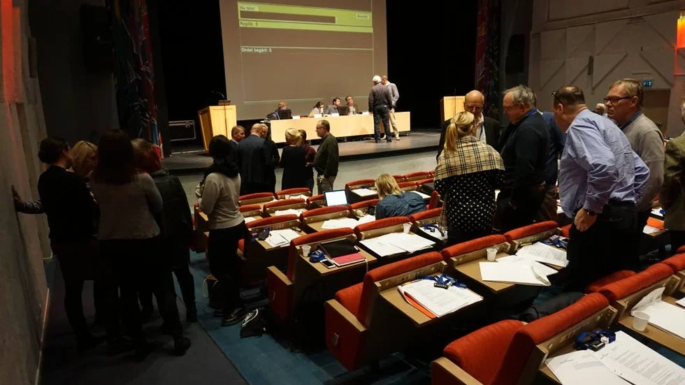 För eller emot? Politikerna står i smågrupper och diskuterar under den korta ajourneringen inför omröstningen om skattesats. Oppositionspartierna ville att den budget som togs i somras ska revideras.