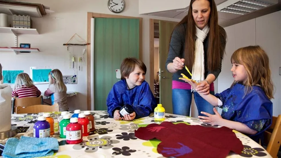 En gul solhand ska Joline Pegestam trycka dit på hjärtat. Edvin örnstedt gör en svart. Barnskötare Karin Rydell hjälper till att måla på färgerna.
