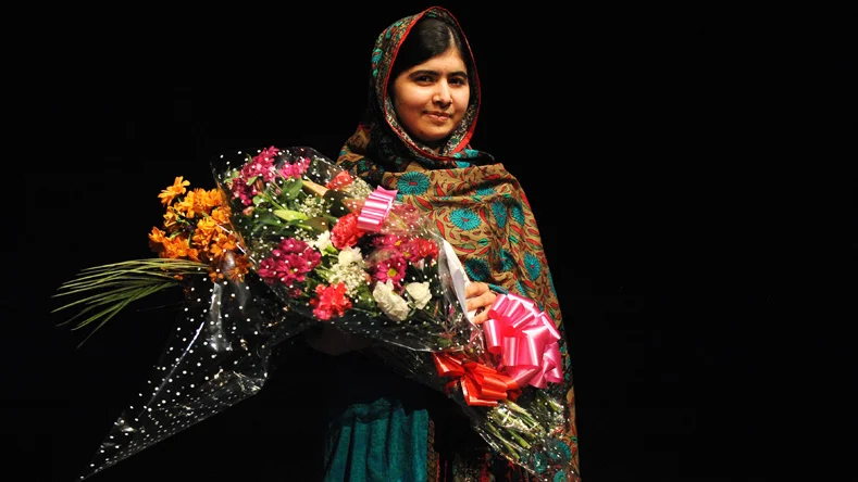 Malala Yousafzai poses with a bouquet after speaking during a media conference at the Library of Birmingham, in Birmingham, England, Friday, Oct. 10, 2014, after she was named as winner of The Nobel Peace Prize.  The Nobel Peace Prize 2014, is awarded jointly to Malala Yousafzai of Pakistan and Kailash Satyarthi of India, for risking their lives to fight for childrens rights. Malala was shot in the head by a Taliban gunman two-years ago in Pakistan for insisting that girls have the right to an education. (AP Photo/Rui Vieira) / TT / kod 436