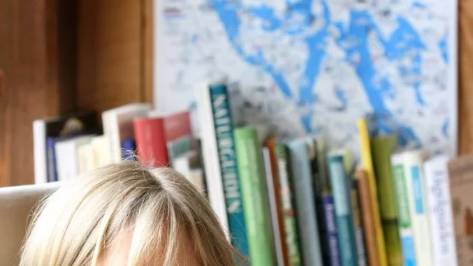 Anna Sandhammar nersjunken i Naturum Sommens nya läshörna.