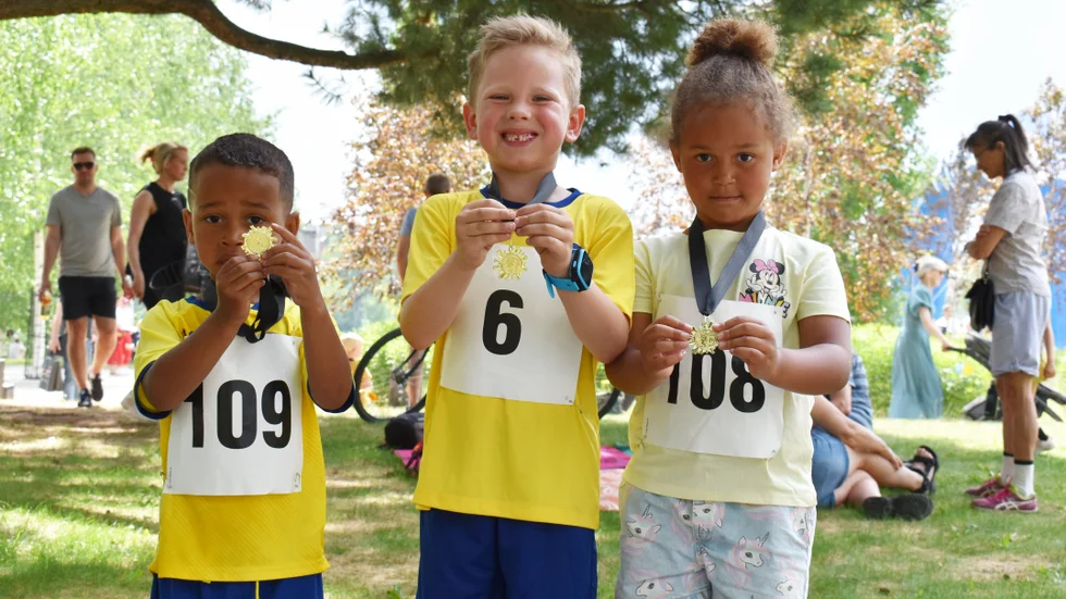 Anthony Turay, Hektor Renman och Natascha Turay visar stolt upp medaljerna de fick efter de gick i mål i barnloppet.
