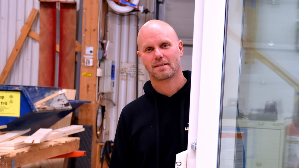 Mattias Jonsson, vd på WB Trä, kikar fram bakom glasdörrar som ska pryda ett antal lägenheter på Stureplan i Stockholm.