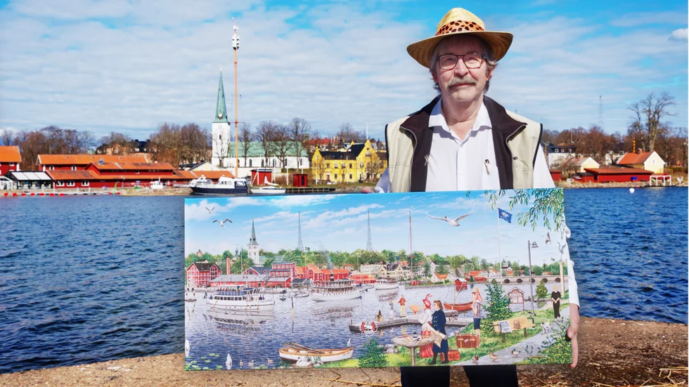 Konstnären Nils-Erik Nilsson visar upp sin målning över Motala.