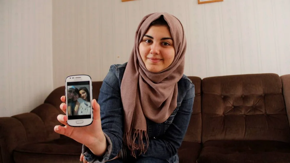 Inte bara flykting. Haya Kojak, 17 år, är en av de boende på flyktinganläggningen i Marma som deltar i Henrik Telemans stora konstprojekt "I telefonen finns hela människan". Här visar hon en bild på sina bästa vänner hemma i Syrien.