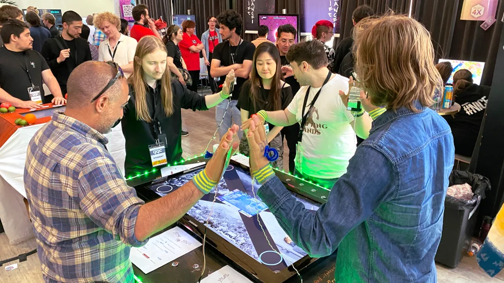 Alicia Jin låter fyra besökare testa spelet "Hum to heal" under Gotland Game Conference 2023.