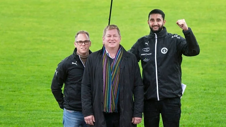 Glada miner trots det idoga regnandet. Bissarnas ordförande, Ahmad Eid (till höger) och kassör, Jonnie Svensson (till vänster) flankerar sin ekonomiska räddare i form av SEB:s kontorschef i Nyköpingsregionen, Göran Arnmark.
