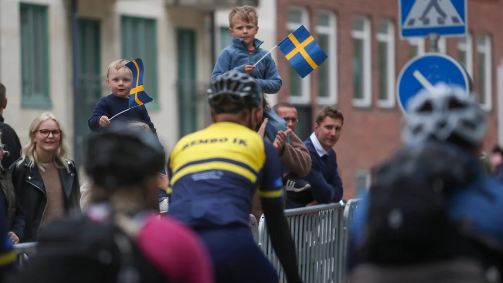 Treårige Nils och femårige Tage hejar på cyklisterna innan de lämnar Motala för en färd runt Vättern.