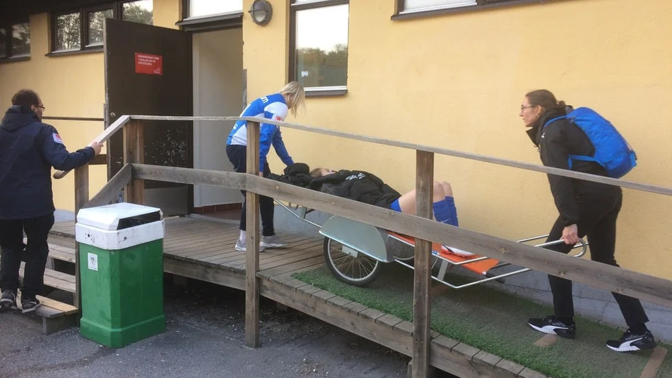 Fiona Brown fick skjutsas från planen till omklädningsrummet i en kärra styrd av sjukgymnasten Annica Svensson (till vänster) och Hammarbys läkare. Foto: Stefan Alhag