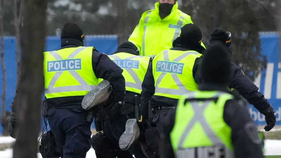En demonstrant bärs bort av polis från den blockerade gränsövergången mellan Kanada och USA, Ambassador Bridge.