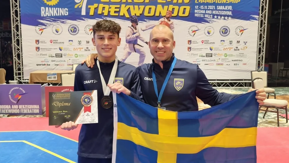 Aron Söderlund firar bronsmedaljen tillsammans med tränaren Niklas Andersson.