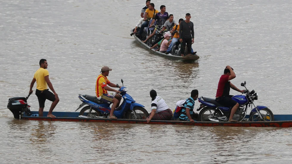 Venezuelaner flyr över floden Arauca, den naturliga gränsen mot Colombia, efter våldsamheter i veckan mellan militär och gerilla.