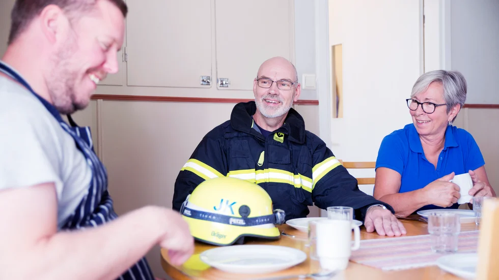 
På arbetsplatsen vet alla att det finns en deltidsbrandman bland dem. "Ibland så försvinner han, då är han på utryckning, säger kollegan Rita Muttoni som jobbar i köket med Dennis Ogeklint. "Det värsta som kan hända är att man missar kålpuddingen", svarar Johnny Kahlström.