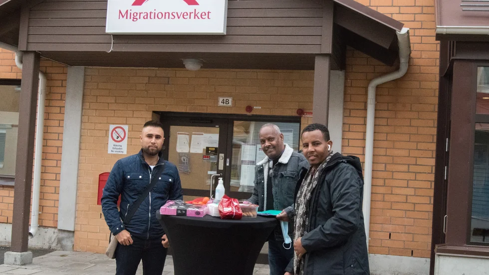 Mujtaba Faizi, Essayas Neguse och Hassan Mohamed har ställt i ordning ett bord med fika utanför Migrationsverket för att locka till sig besökarna att komma och prata vaccin med dem.