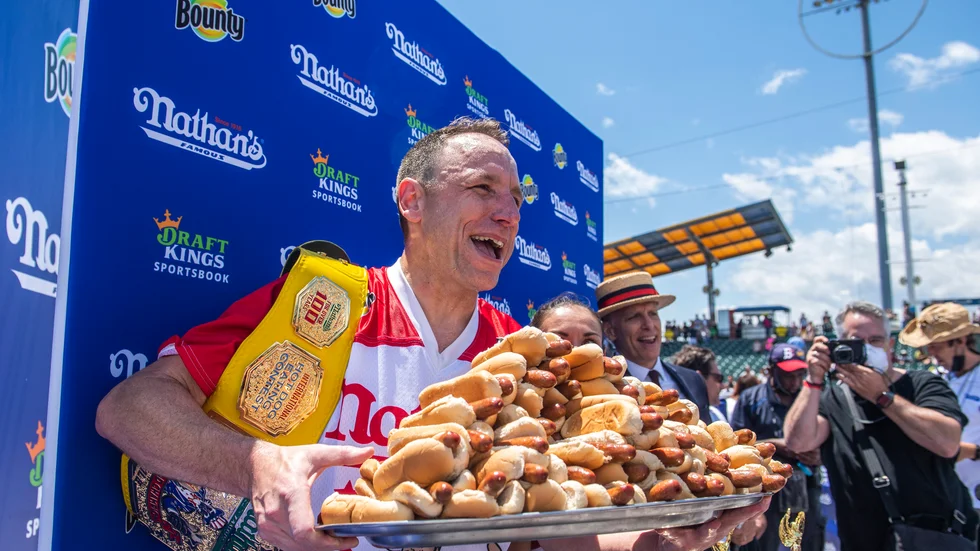 Korvätarmästaren Joey Chestnut jublar med en bricka korv med bröd i famnen efter segern på Coney Island. 76 stycken klämde han i sig.