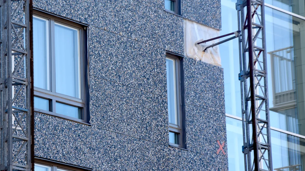 Det blev inget glitter i den nya fasaden heller, den består av plattor i grå terrazzosten.