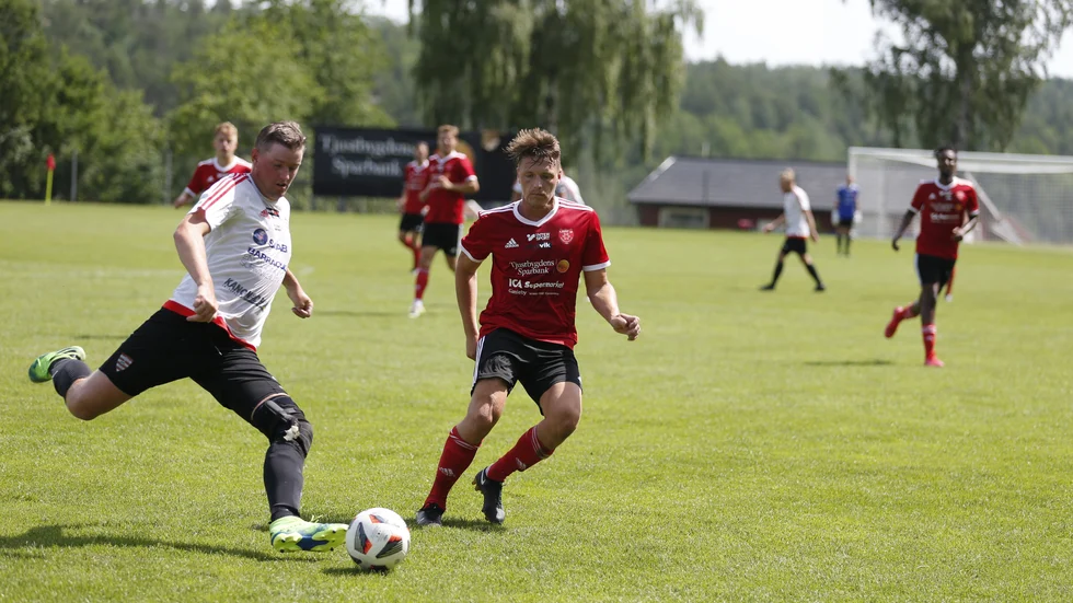 Hammarsgärdes Emil Bäck slår undan bollen precis framför Tjusts Robin Lundahl.
