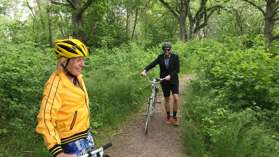 Vätternrundans vd:ar Gunilla Brynell-Johansson och Oskar Sundblad har fått kämpa sig upp för den smala och tuffa Mariebergsbacken. Snart bär det skönt utför. Sportens krönikör tog med duon på flanörcykling runt om i Motala.