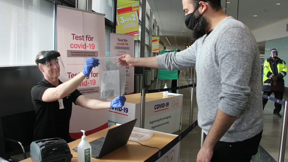 Wincent Johansson delar ut ett test-kit till Edvin Alam, en av många som testat sig på Arlanda. Det känns väldigt meningsfullt att jobba med det här. Många vill testa sig, säger Wincent Johansson.