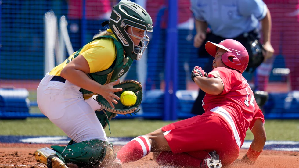 Japans Minori Naito, till höger, och Australiens Taylah Tsitsikronis i OS-premiären i softball i Fukushima.