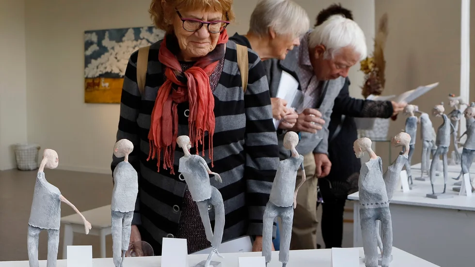 Några av Sanna Koosz figurer studeras av besökarna.