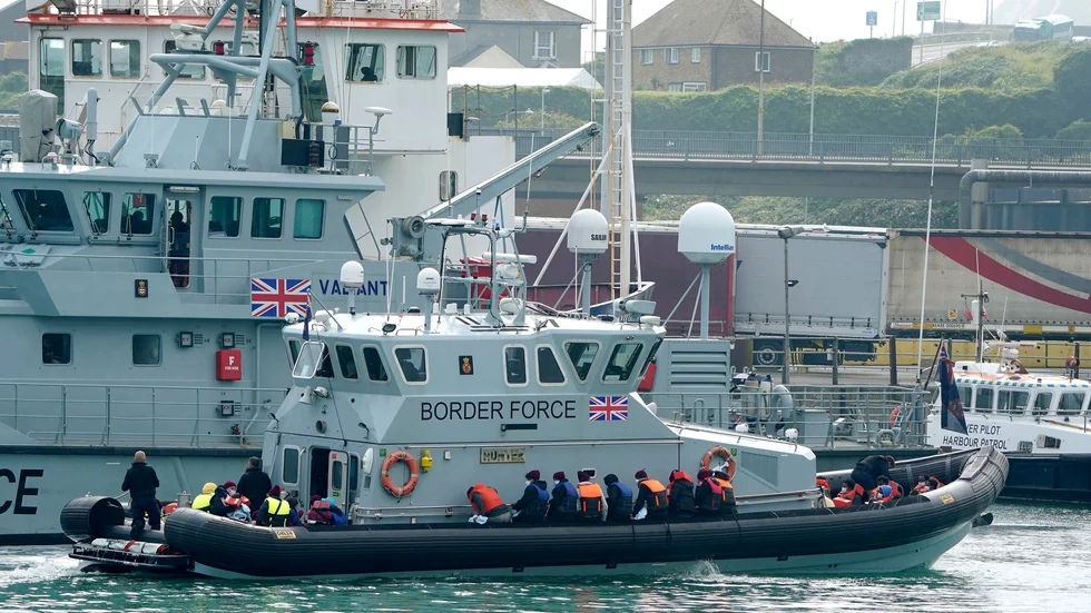 En grupp migranter förs in till hamn av den brittiska kustbevakningen. Arkivbild