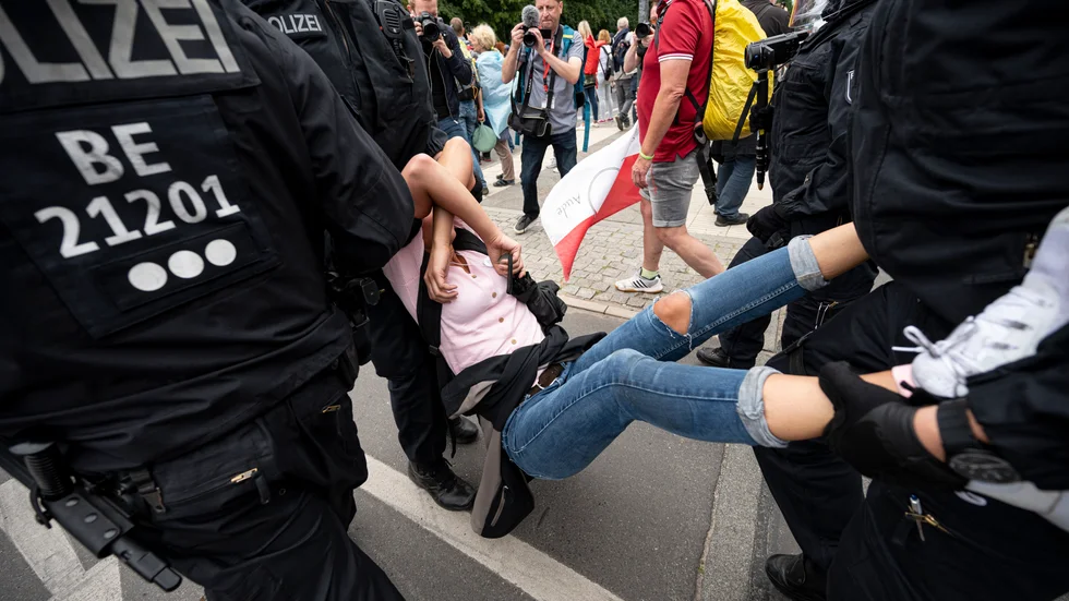 Polis griper en deltagare i den olagliga demonstrationen mot Tysklands coronaregler i Berlin på söndagen.