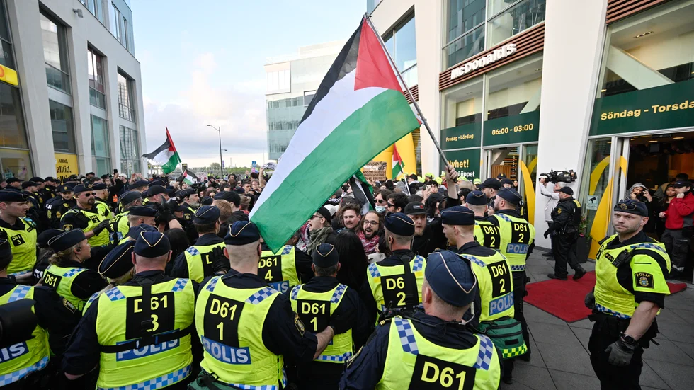 Demonstranter möts av en mur av poliser utanför Malmö Arena i samband med Eurovisionfinalen. Arkivbild.