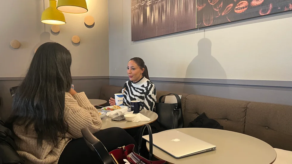 Studenterna Yokabed Yohannes och Lollo Shkuntana avnjuter varsin lunchmacka.