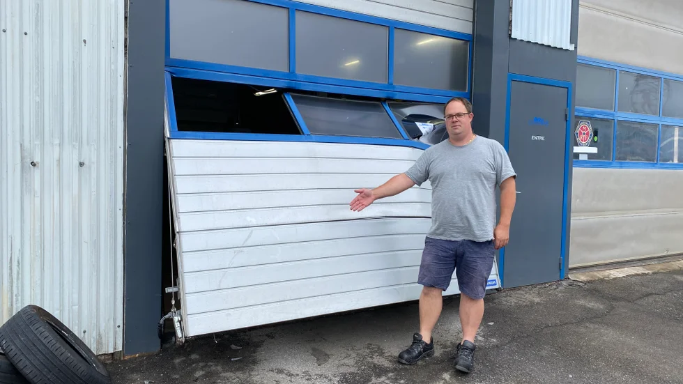 Christopher Andreasson visar porten, som förstördes efter att biltjuven stal en bil och rammade porten för att ta sig ut från byggnaden efteråt.